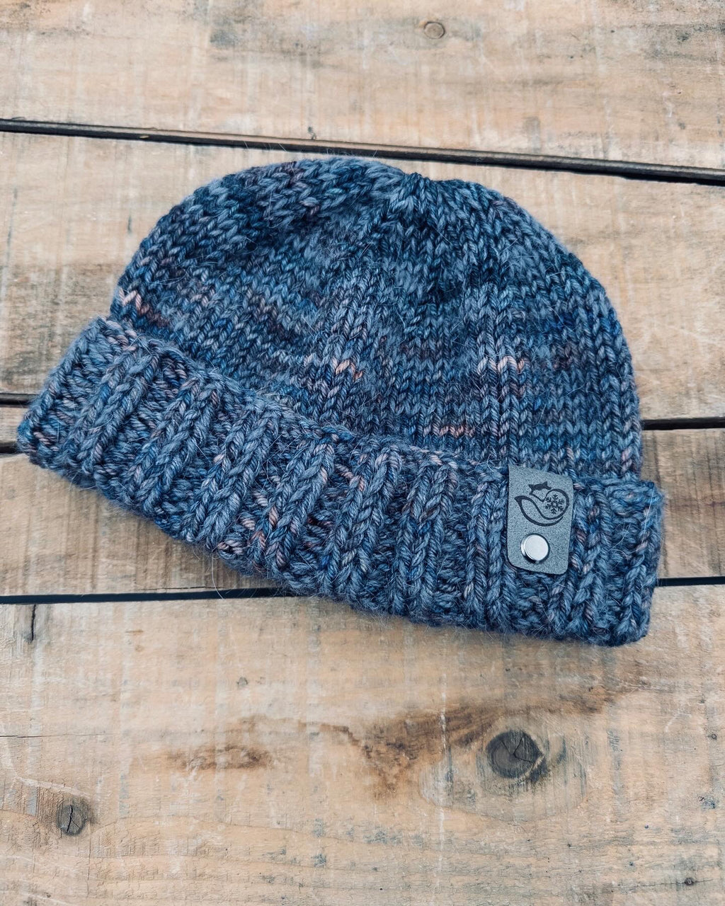 Hand knit BBK fisherman hat in Scorpio featuring folded brim design in soft merino wool and mohair on rustic wood background