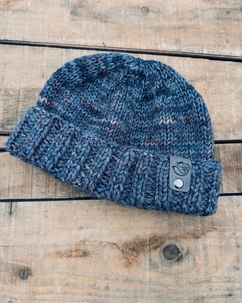 Hand knit BBK fisherman hat in Scorpio featuring folded brim design in soft merino wool and mohair on rustic wood background