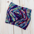Hand knit Mecha merino wool twist headband in Anniversario colorway featuring vibrant jewel tones of teal, magenta, purple, and blue