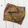 Hand knit Mecha merino wool twist headband in Piedras colorway featuring earthy olive, gold, and plum tonal variation
