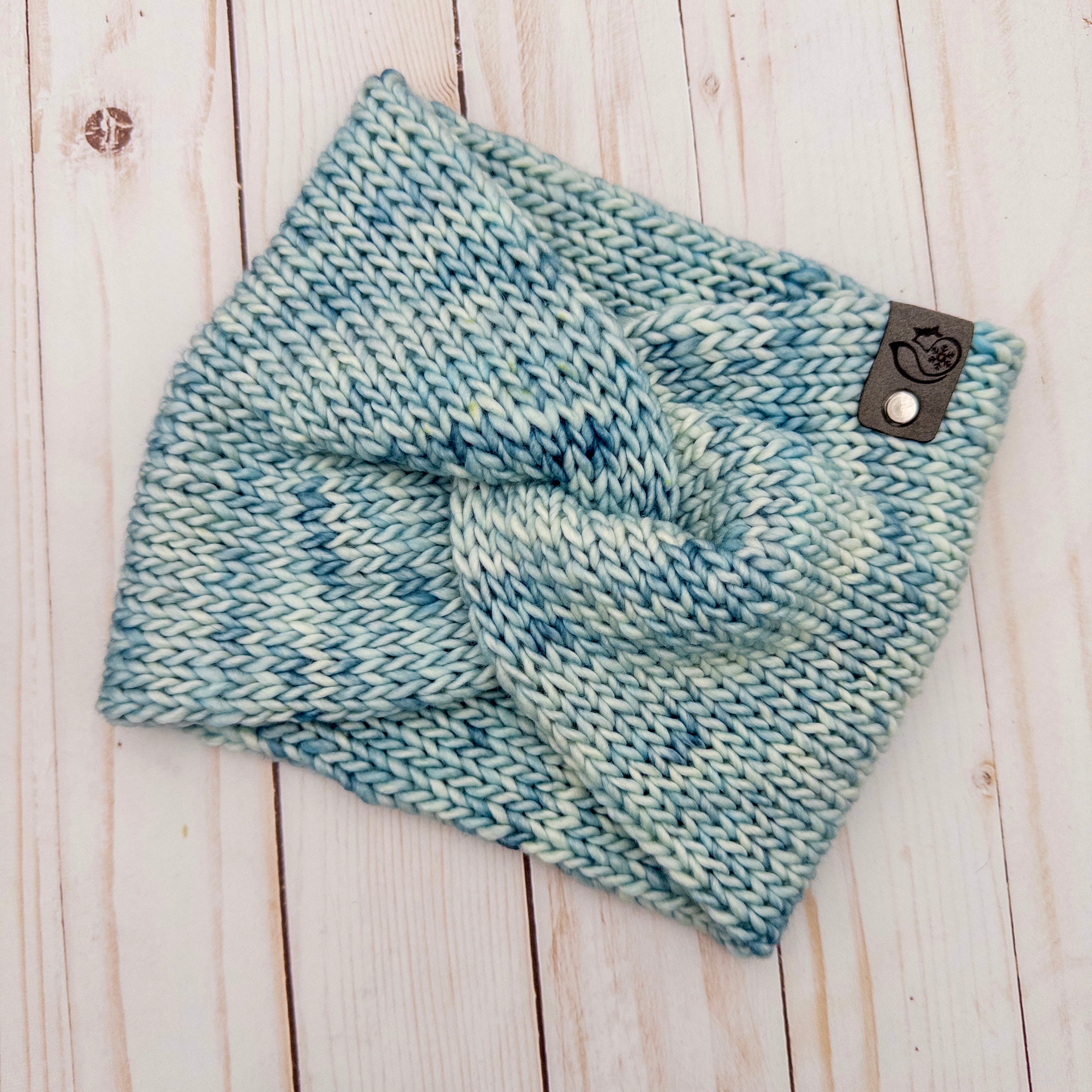 Hand knit Mecha merino wool twist headband in Thereza colorway featuring soft icy blue and pale aqua tonal variation